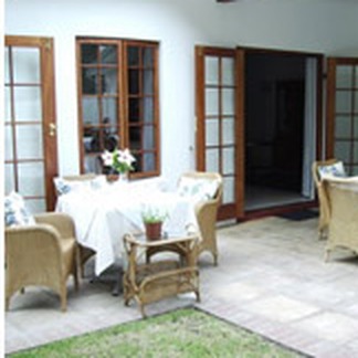 Veranda dining with wicker chairs and french doors